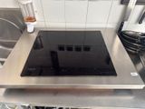 a stove top with a black burner on it in a kitchen