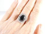 an image of a woman ' s hand holding a black and white diamond ring
