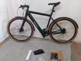 un vélo posé par terre devant un mur blanc