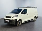 La camionnette blanche est garée dans une pièce aux murs blancs.
