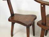 two wooden chairs sitting next to each other on a white floor