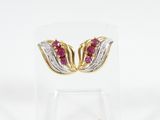 a pair of ruby and diamond earrings on a clear stand