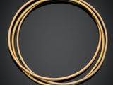 une paire de bracelets en or sur fond noir