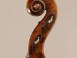 an antique violin with a scroll on the back of it
