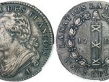 a silver coin with an image of a man on it