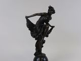 bronze figurine of a woman with a bow on a pedestal
