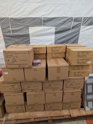 une pile de cartons posée sur une palette, à côté d'une autre pile de cartons