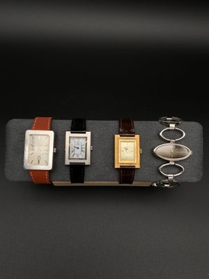 un assortiment de montres et d'autres objets exposés sur un fond noir