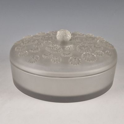 une boîte blanche munie d'un couvercle orné d'un motif floral