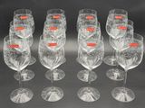 six clear wine glasses with red labels are lined up in a row