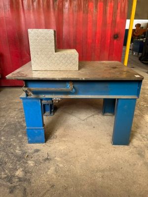 a blue table with a block on top of it in front of a red wall