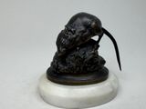 une statue représentant un rat posée sur un socle en marbre
