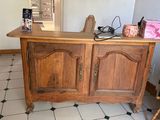 a wooden cabinet with a mirror on top of it in a room
