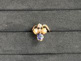 a close up of a gold ring with a blue and white stone