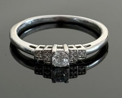an image of a diamond ring on a black surface