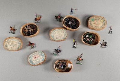 plusieurs figurines miniatures représentant des personnes, disposées dans des bols en bois posés sur une table