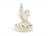 statue d'un coq posé sur un rocher, sur fond blanc