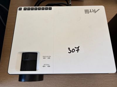 une photo d'un projecteur blanc posé sur une table en bois