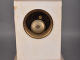 a small white clock with a brass bell on it