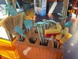 many brooms and brushes in a wooden box on a table