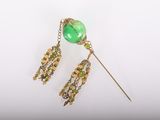 gros plan sur une paire de boucles d'oreilles avec des perles vertes