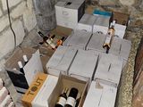 many boxes of wine sitting on the floor next to a brick wall