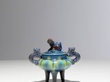 a blue and green vase sitting on top of a table
