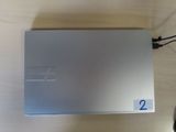 a silver sony playstation game console sitting on a wooden table