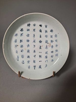 a white plate with blue writing on it on a table