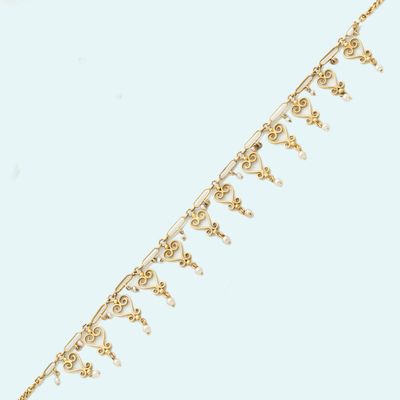 a close up of a gold chain with a bunch of beads on it