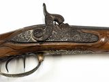 an old gun that is on display on a white surface