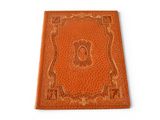 a brown leather book with an ornate design on the cover