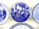 four blue and white plates with pictures of people on them