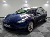 the blue tesla model 3 is parked in a showroom
