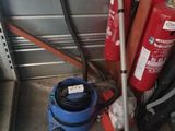 un extincteur rouge à côté d'un seau bleu