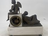 a statue of an angel sitting on top of a clock