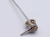a silver and gold brooch with a dagger on it