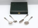 four silver spoons and a box on a table