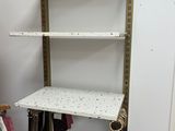 une étagère sur laquelle sont posés quelques vêtements, dans une pièce