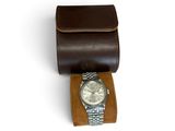 brown leather watch case with a watch on it and a watch in it