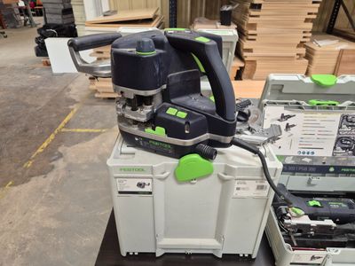 a green and black orbital sander sitting on top of a white box