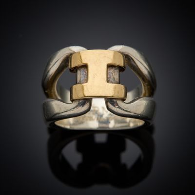 a close up of a silver and gold ring on a black surface