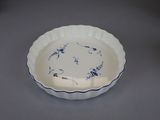 a white bowl with blue flowers on it on a table
