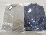 two pairs of shirts wrapped in plastic bags on the floor