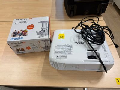 un projecteur blanc posé sur une table à côté d'une boîte