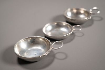 trois bols en argent posés les uns à côté des autres sur une table