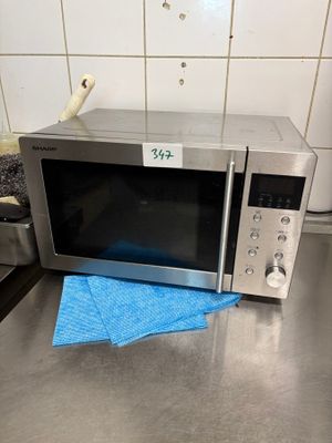 un micro-ondes posé sur un plan de travail recouvert d'un linge bleu