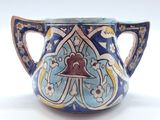 un vase bleu et jaune orné d'une clochette