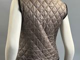 the back view of a mannequin wearing a silver quilted vest