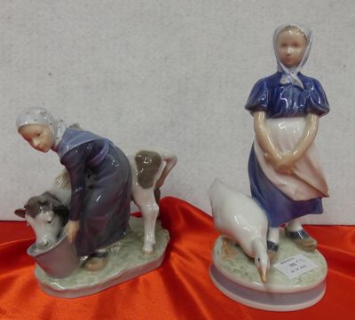 two figurines of a woman and a dog on a table